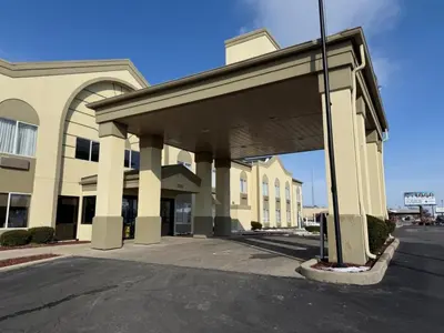 a building with a large overhang in a parking lot at SureStay by Best Western Marion in Marion
