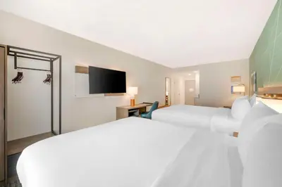 a hotel room with two beds and a flat screen tv at Comfort Suites Fort Wayne - Southwest in Fort Wayne