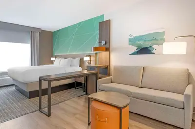 a hotel room with a bed and a couch at Comfort Suites Fort Wayne - Southwest in Fort Wayne