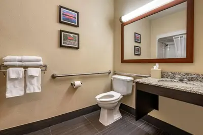 a bathroom with a toilet and a sink and a mirror at Comfort Inn Shelbyville North in Shelbyville