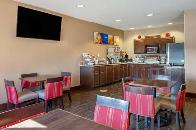 a restaurant with tables and chairs and a kitchen at Comfort Inn Shelbyville North in Shelbyville