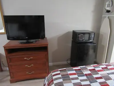 a bedroom with a tv and a dresser with a bed at Red Roof Inn Walton, KY - Richwood - Cincinnati Airport South in Richwood