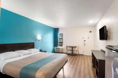 a bedroom with a large bed and a blue wall at Motel 6-Lexington, KY - Airport in Lexington