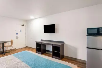 a room with a desk and a tv on a wall at Motel 6-Lexington, KY - Airport in Lexington