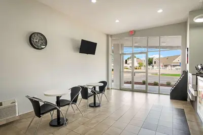 a dining room with tables and chairs and a clock on the wall at Motel 6-Lexington, KY - Airport in Lexington