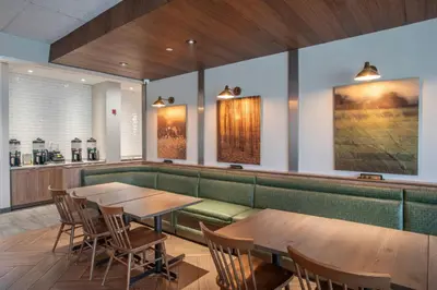 a restaurant with two tables and chairs and a bar at Fairfield by Marriott Inn & Suites Newport Cincinnati in Newport