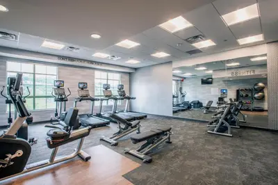 a gym with treadmills and cardio equipment in a room at Fairfield by Marriott Inn & Suites Newport Cincinnati in Newport