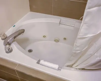 a bathtub with a roll of toilet paper in it at Comfort Suites Georgetown in Georgetown