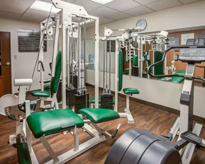 a gym with green chairs and equipment in a room at Comfort Suites Georgetown in Georgetown