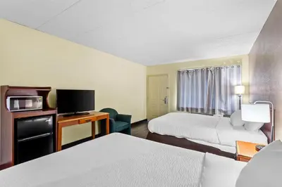 a hotel room with two beds and a flat screen tv at Americas Best Value Inn Grayson in Grayson
