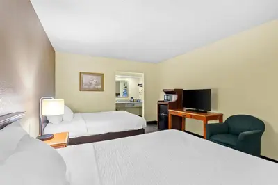 a hotel room with two beds and a television at Americas Best Value Inn Grayson in Grayson