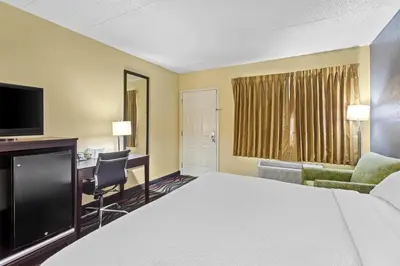 a hotel room with a bed and a desk at Americas Best Value Inn Grayson in Grayson