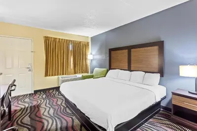 a hotel room with a large bed and a window at Americas Best Value Inn Grayson in Grayson