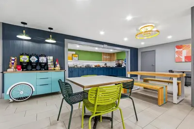 a kitchen with a table and chairs in a restaurant at Spark by Hilton Lexington Hamburg in Lexington