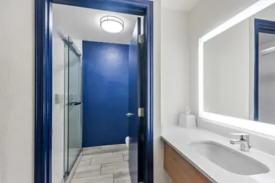 a bathroom with a sink and a blue door at Spark by Hilton Lexington Hamburg in Lexington