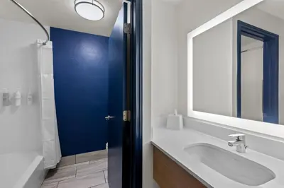 a bathroom with a sink and a large mirror at Spark by Hilton Lexington Hamburg in Lexington