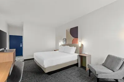 a hotel room with a bed and a chair at Spark by Hilton Lexington Hamburg in Lexington