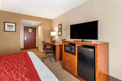 a hotel room with a bed and a flat screen tv at Comfort Inn & Suites Morehead in Morehead