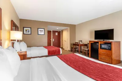 a hotel room with two beds and a flat screen tv at Comfort Inn & Suites Morehead in Morehead