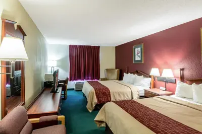 a hotel room with two beds and a television at Red Roof Inn Morehead in Morehead