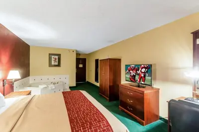 a hotel room with a bed and a flat screen tv at Red Roof Inn Morehead in Morehead