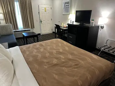 a hotel room with a bed and a flat screen tv at Quality Inn Ashland in Ashland