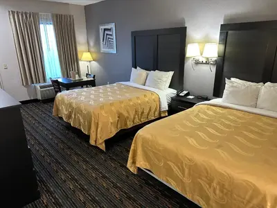 a hotel room with two beds with yellow sheets at Quality Inn Ashland in Ashland