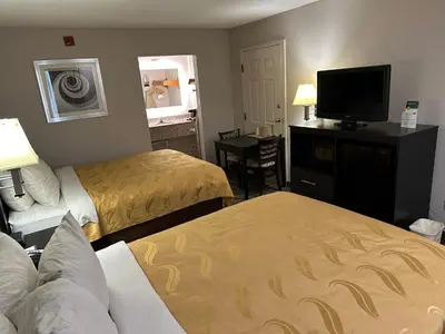 a hotel room with two beds and a flat screen tv at Quality Inn Ashland in Ashland