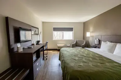 a hotel room with a bed and a desk at Quality Inn Carrollton in Carrollton