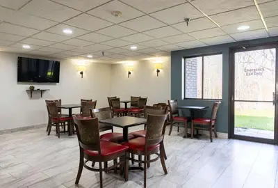 a dining room with tables and chairs and a flat screen tv at Quality Inn Carrollton in Carrollton