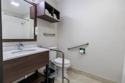 a bathroom with a toilet and a sink and a mirror at Quality Inn Carrollton in Carrollton