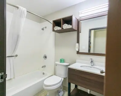 a bathroom with a toilet and a sink and a tub at Quality Inn Carrollton in Carrollton