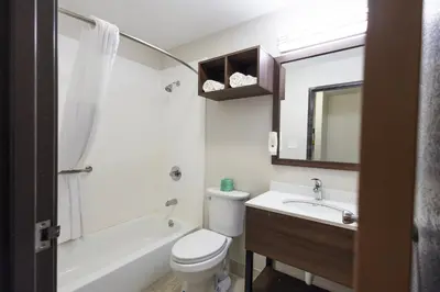 a bathroom with a toilet and a sink and a tub at Quality Inn Carrollton in Carrollton