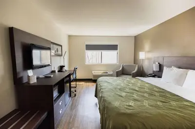 a hotel room with a bed and a flat screen tv at Quality Inn Carrollton in Carrollton