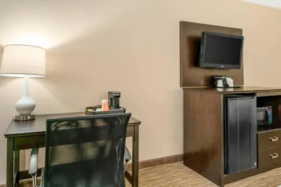 a hotel room with a desk and a tv at Quality Inn & Suites Monroe in Monroe