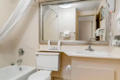 a bathroom with a toilet and a sink and a mirror at Quality Inn & Suites Monroe in Monroe