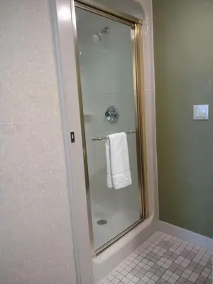 a shower with a glass door with a white towel at Baymont by Wyndham Flat Rock in Flat Rock