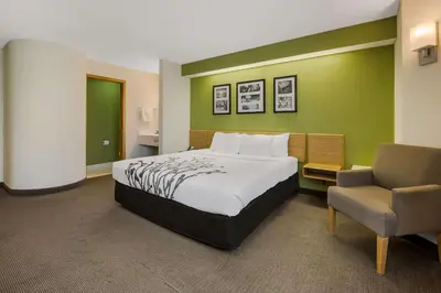 a hotel room with a bed and a chair at Sleep Inn Bolivar in Bolivar
