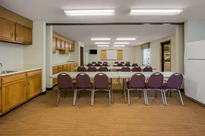 a conference room with a long table and purple chairs at Sleep Inn Bolivar in Bolivar