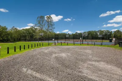 a gravel driveway with a basketball court in a park at Sleep Inn Bolivar in Bolivar