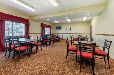 a dining room with tables and chairs and a screen at Quality Inn Greenville North in Greenville