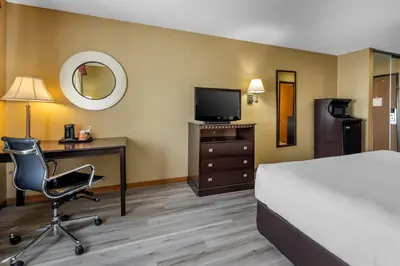 a hotel room with a bed and a desk and a chair at Quality Inn Greenville North in Greenville