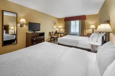 a hotel room with two beds and a television at Quality Inn Greenville North in Greenville