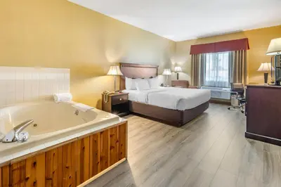 a hotel room with a bed and a bath tub at Quality Inn Greenville North in Greenville