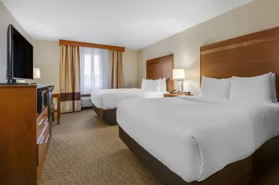 a hotel room with two beds and a flat screen tv at Comfort Inn Millersburg in Millersburg