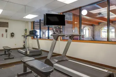 a gym with two tread machines and a flat screen tv at Comfort Inn Millersburg in Millersburg