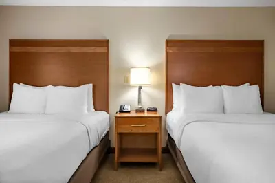 a hotel room with two beds and a table with a lamp at Comfort Inn Millersburg in Millersburg