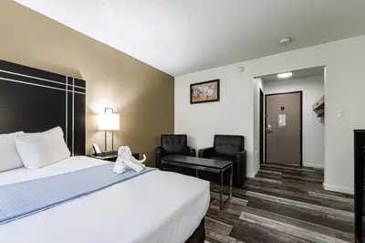 a hotel room with a bed and a desk and chairs at Econo Lodge Cleveland Southeast - Kent in Streetsboro