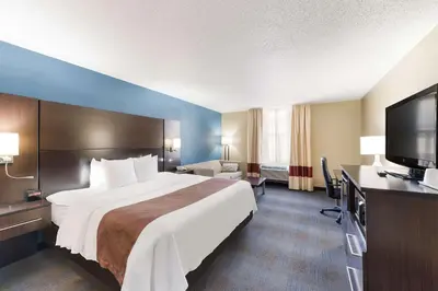 a hotel room with a large bed and a flat screen tv at Quality Inn Upper Sandusky in Upper Sandusky