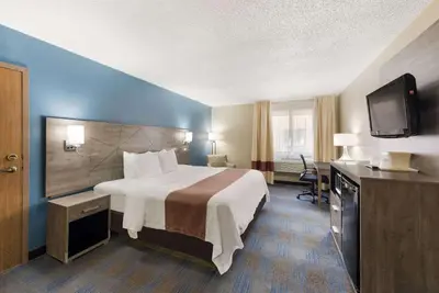 a hotel room with a bed and a flat screen tv at Quality Inn Upper Sandusky in Upper Sandusky